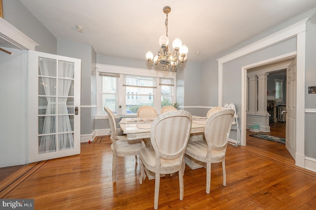 dining area with hardwood / wood-style floors and an inviting chandelier