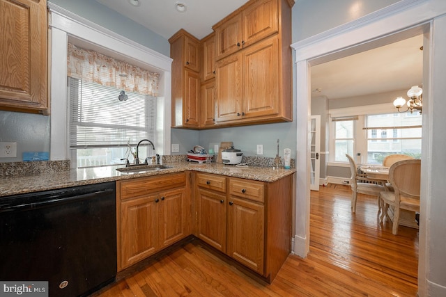 kitchen with sink, light hardwood / wood-style flooring, a chandelier, and black dishwasher