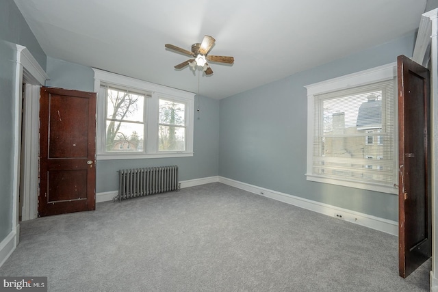 unfurnished bedroom with radiator, ceiling fan, and light carpet