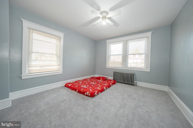 interior space with a wealth of natural light, radiator, and ceiling fan