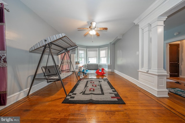 playroom featuring decorative columns, ceiling fan, and hardwood / wood-style floors