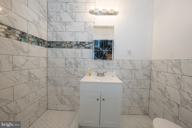 bathroom featuring vanity and tile walls