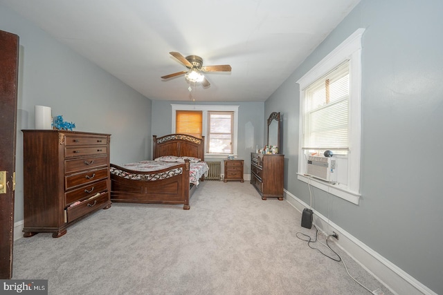 carpeted bedroom with ceiling fan, cooling unit, radiator, and multiple windows