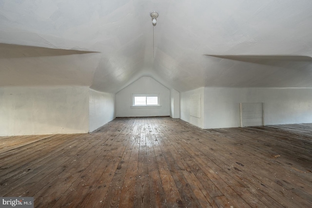 bonus room with lofted ceiling and dark hardwood / wood-style floors