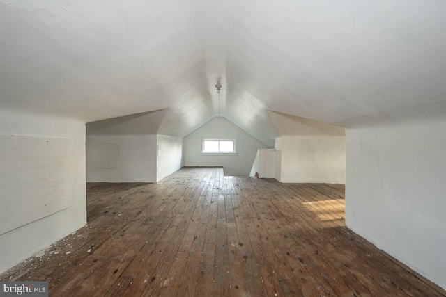 additional living space featuring dark hardwood / wood-style flooring and vaulted ceiling