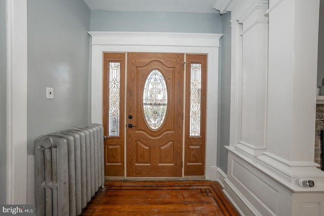 entrance foyer with dark wood-type flooring and radiator