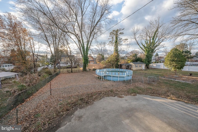 view of yard with a fenced in pool and an outdoor structure