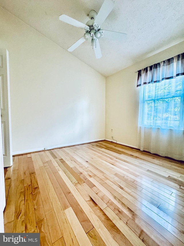 unfurnished room with a textured ceiling, light hardwood / wood-style floors, and ceiling fan