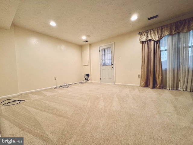 carpeted empty room with a textured ceiling