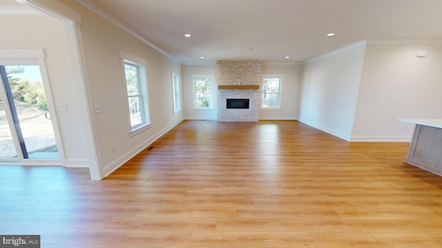 unfurnished living room featuring light hardwood / wood-style floors, crown molding, and a fireplace