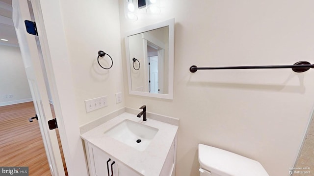 bathroom featuring hardwood / wood-style flooring, vanity, and toilet