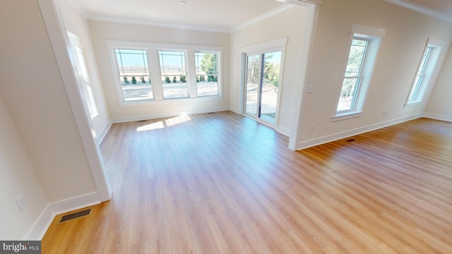 interior space with light hardwood / wood-style floors and ornamental molding