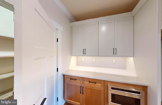 kitchen with tasteful backsplash and white cabinetry