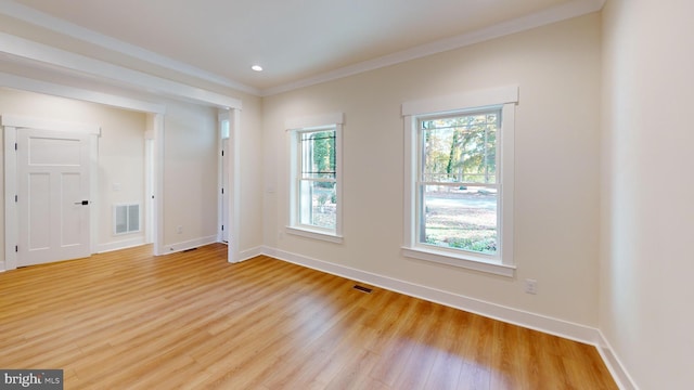 spare room featuring light hardwood / wood-style flooring and crown molding