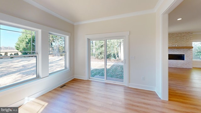 interior space with light hardwood / wood-style floors, ornamental molding, and a fireplace