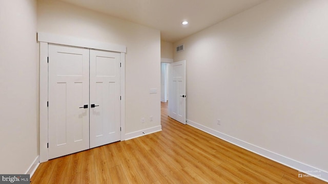 unfurnished bedroom featuring a closet and light hardwood / wood-style flooring