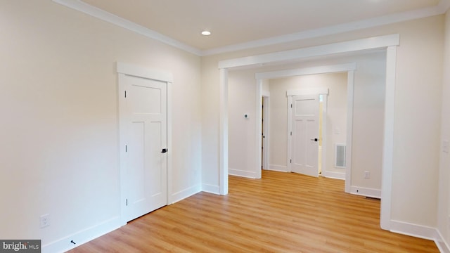 interior space with light hardwood / wood-style floors and ornamental molding