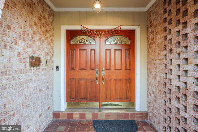 view of exterior entry featuring brick siding