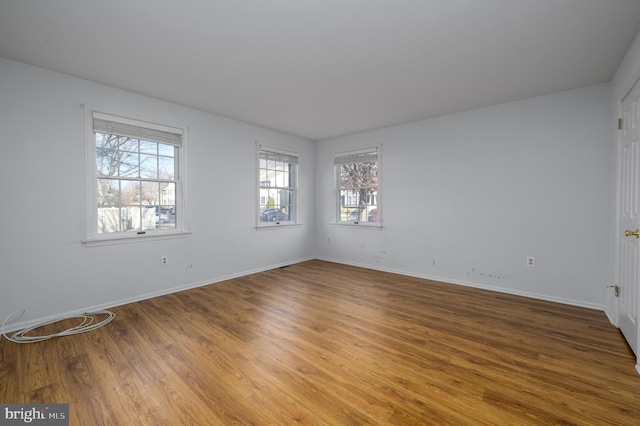 empty room featuring wood-type flooring and plenty of natural light