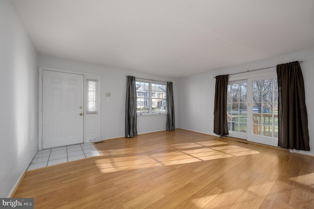 foyer entrance featuring plenty of natural light and light hardwood / wood-style flooring