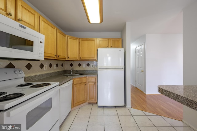 kitchen with white appliances, light hardwood / wood-style floors, tasteful backsplash, and sink