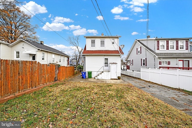 rear view of house featuring a yard