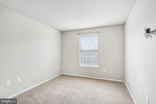 carpeted spare room with a textured ceiling