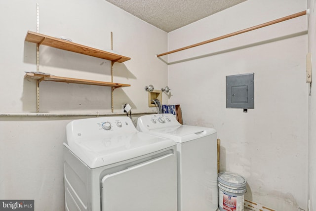 laundry area featuring washer and clothes dryer, a textured ceiling, and electric panel