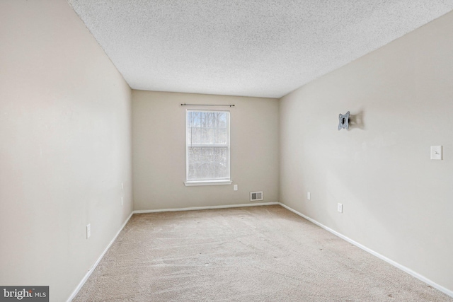 empty room with light carpet and a textured ceiling