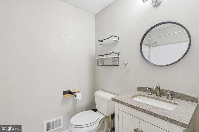 bathroom featuring vanity, toilet, and a textured ceiling