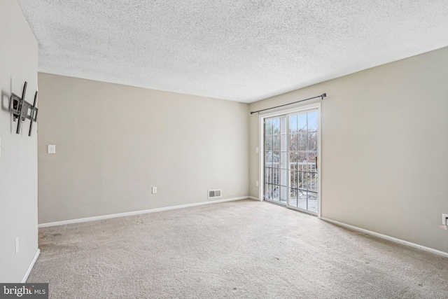 carpeted spare room featuring a textured ceiling