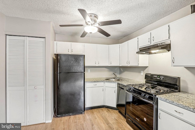 kitchen featuring black appliances, light hardwood / wood-style floors, white cabinets, and a textured ceiling