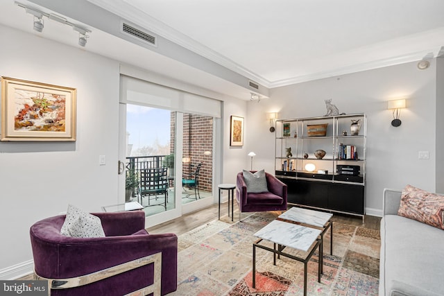 living room featuring hardwood / wood-style floors, rail lighting, and ornamental molding