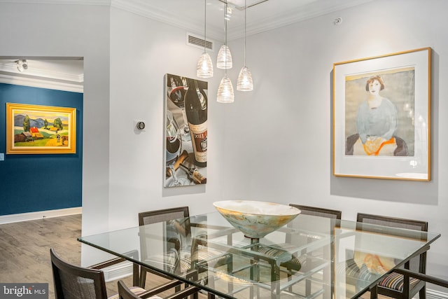 dining room with hardwood / wood-style flooring and ornamental molding