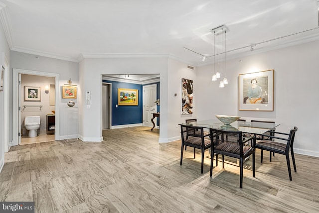 dining space featuring rail lighting and ornamental molding