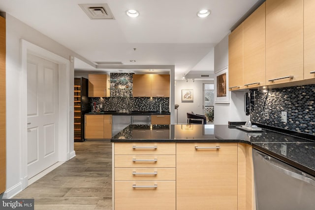 kitchen featuring dishwasher, light hardwood / wood-style flooring, kitchen peninsula, dark stone countertops, and light brown cabinetry