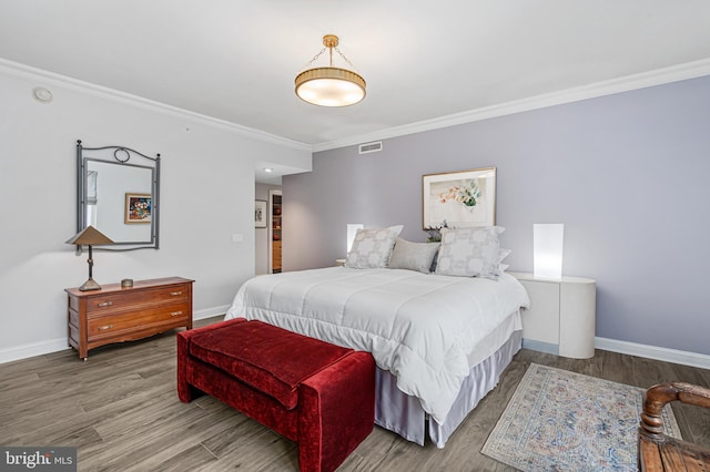 bedroom with crown molding and hardwood / wood-style flooring