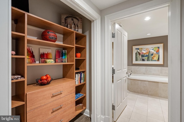 interior space featuring tile patterned floors and tiled tub