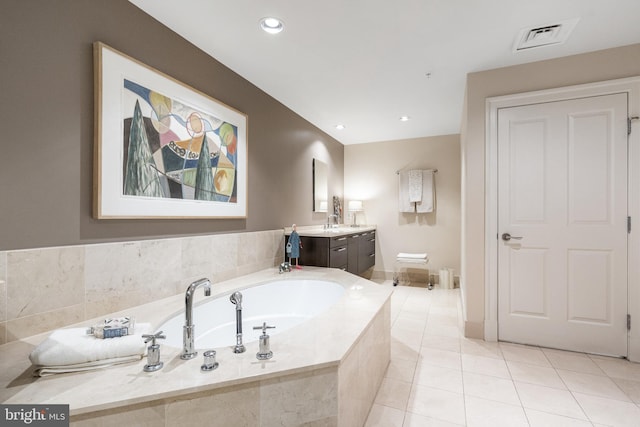 bathroom featuring vanity, tiled bath, and tile patterned floors