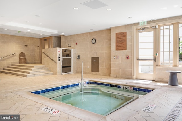 view of swimming pool featuring an indoor hot tub