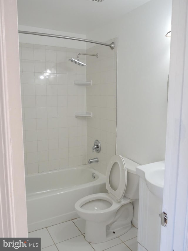 full bathroom with tile patterned floors, vanity, tiled shower / bath combo, and toilet