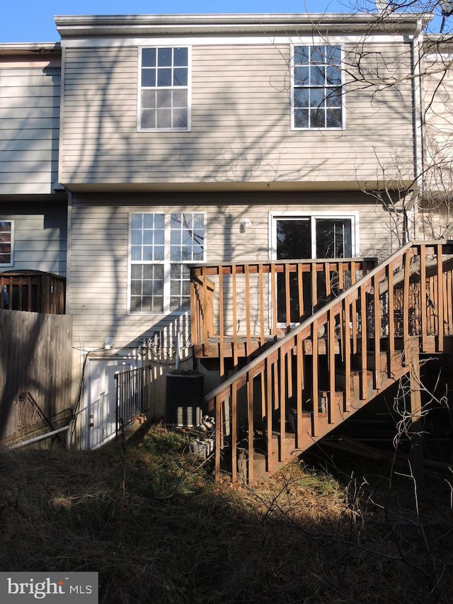 rear view of house with central AC unit and a deck