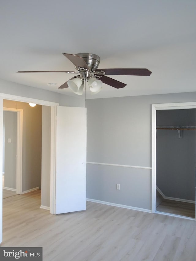 unfurnished bedroom with ceiling fan, a closet, and light wood-type flooring