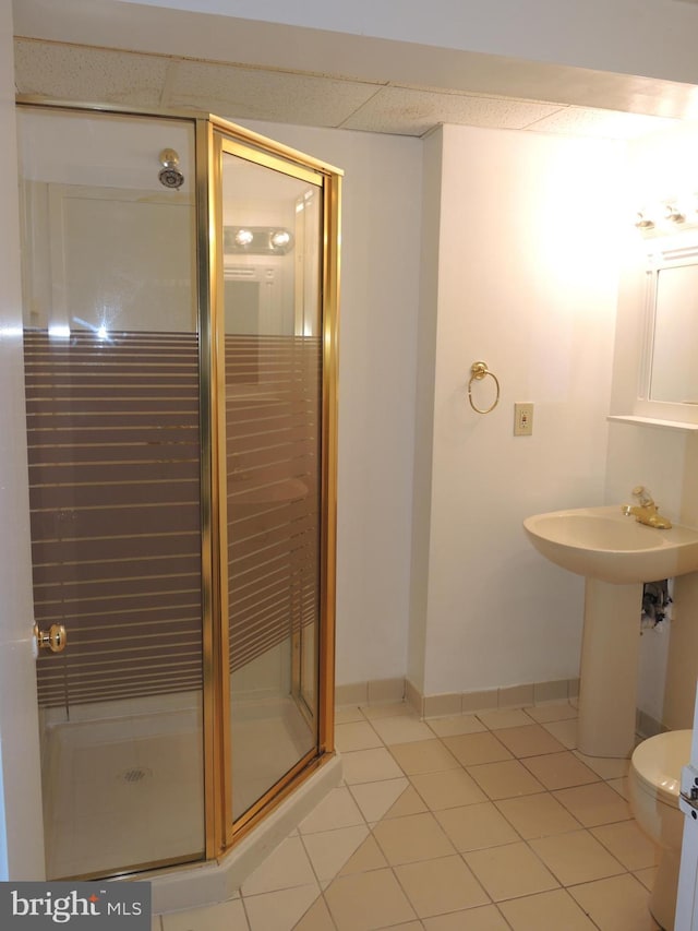 bathroom with tile patterned flooring, toilet, a shower with shower door, and sink