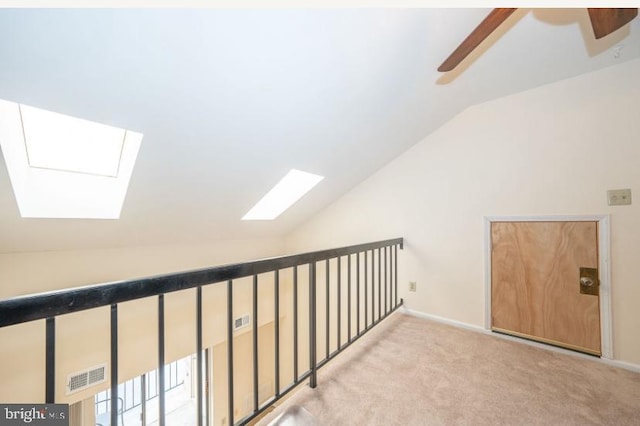 additional living space with light carpet, ceiling fan, and lofted ceiling with skylight