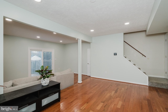 basement featuring hardwood / wood-style flooring and a textured ceiling