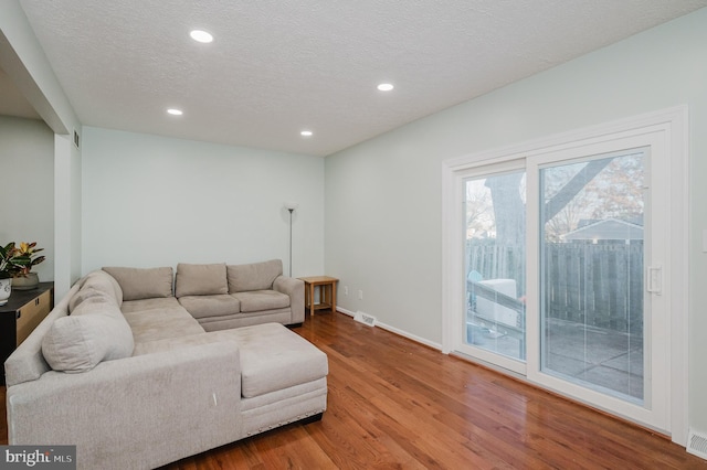 living room featuring hardwood / wood-style floors and a textured ceiling