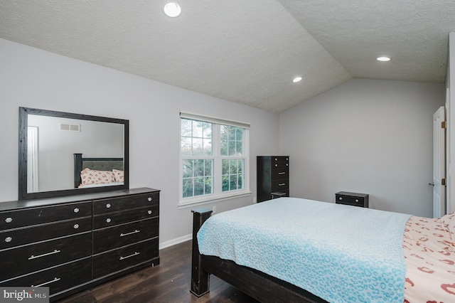 bedroom with lofted ceiling, dark wood-type flooring, and a textured ceiling