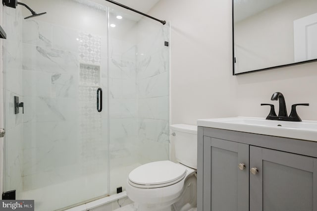 bathroom featuring vanity, an enclosed shower, and toilet