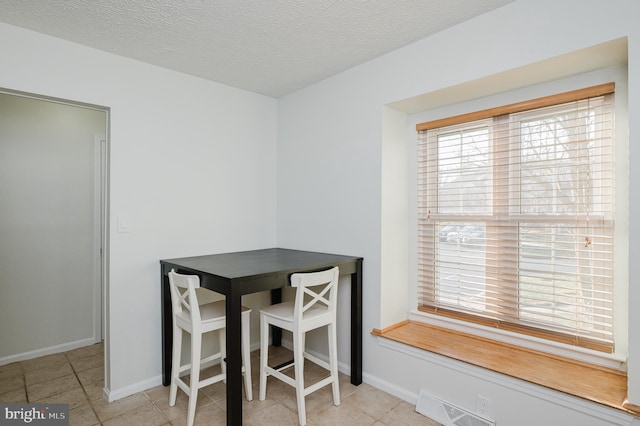 dining area with light tile patterned floors and a textured ceiling